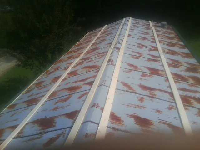 Rusted metal roof panels with new wood purlins before replacement — Storm Damage Roof Repair in Pomaria by Roofing Brothers