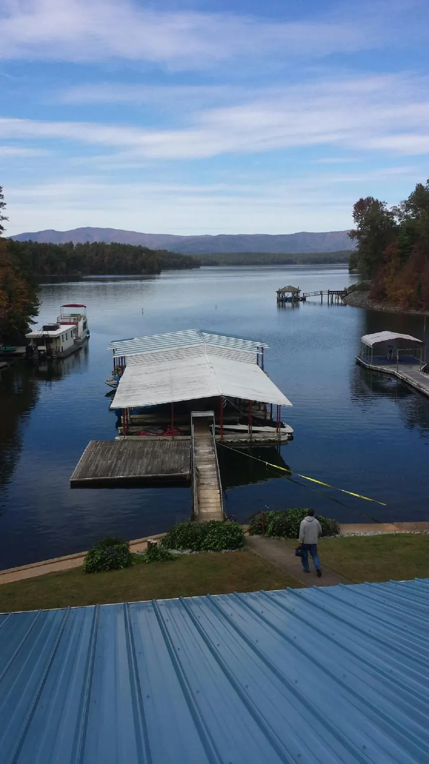 View across a lake from a newly installed blue metal roof in Pomaria