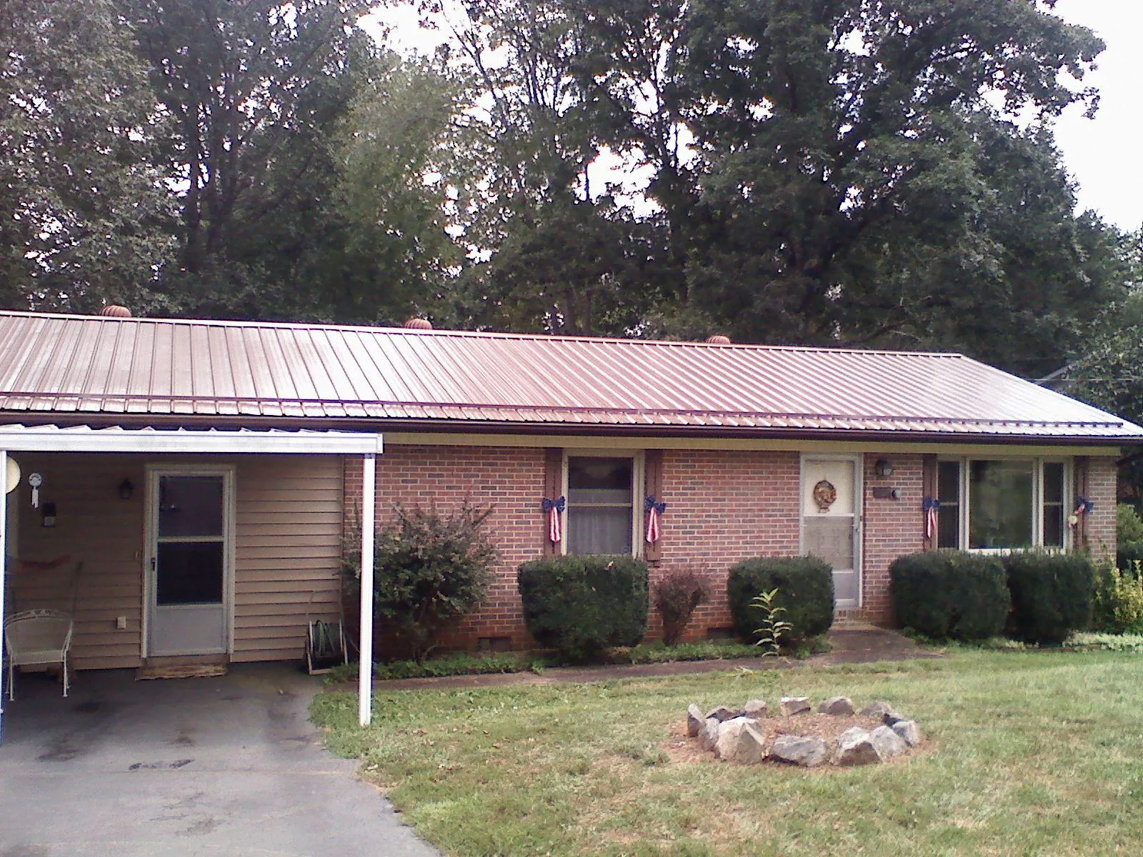 Bronze metal roof and carport on a brick ranch home — Roof Repair work by our crew in Pomaria